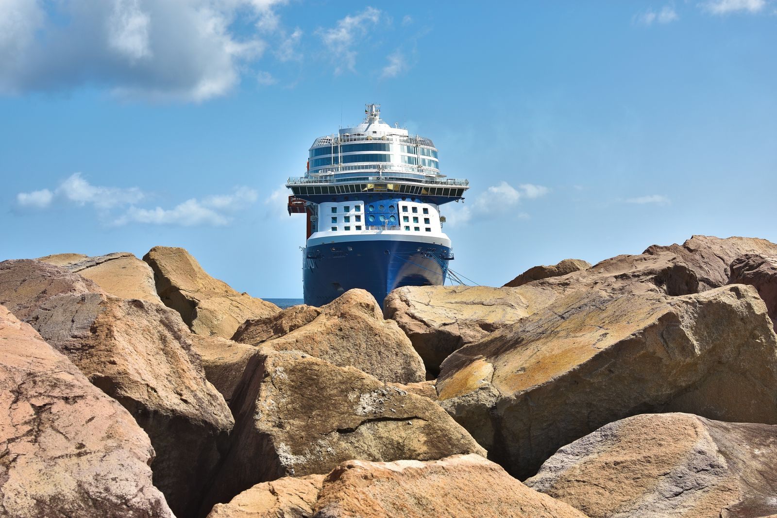 Cruise ship docked behind a rocky shore at Port Zante, St. Kitts, a Caribbean port in the best cruise sales of the year