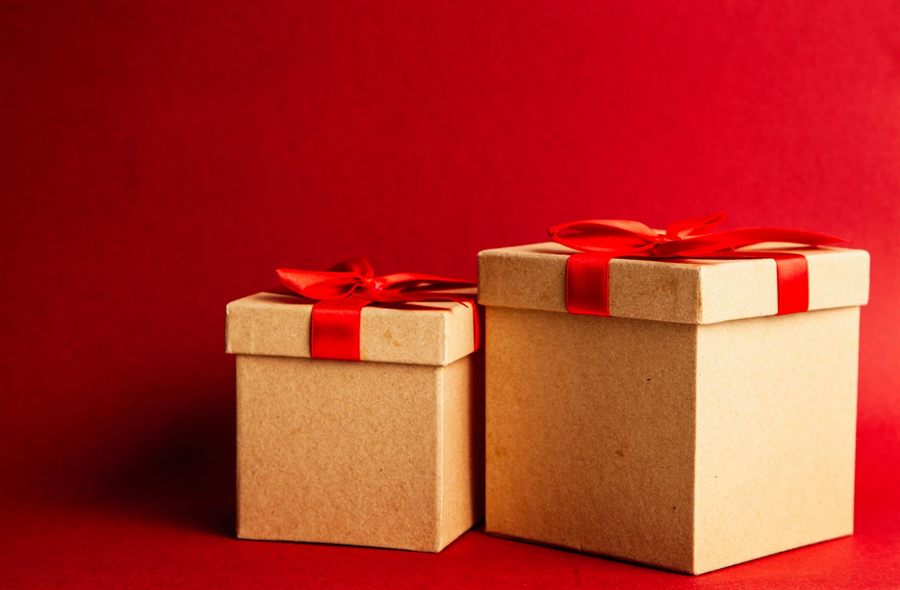 Two gift boxes with red ribbons on a red background