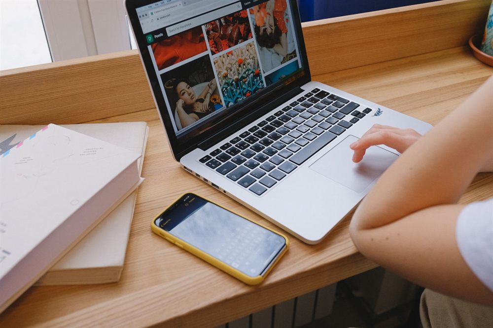 Laptop, phone and notebooks on a wooden desk