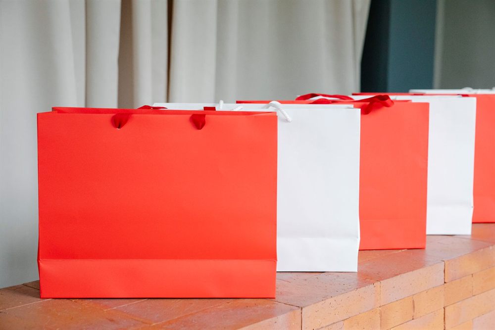 Red and white paper shopping bags on a shelf
