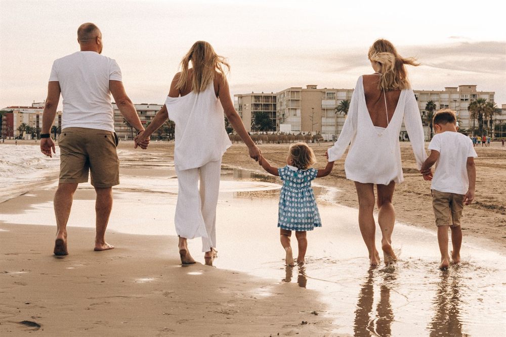 Family walking hand in hand along a beach